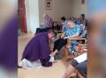 Macleay Valley Catholic Parish priest Father James Foster at Vincent Court Aged Care re-enacting the washing of the feet that Jesus did at the Last Supper. Picture supplied
